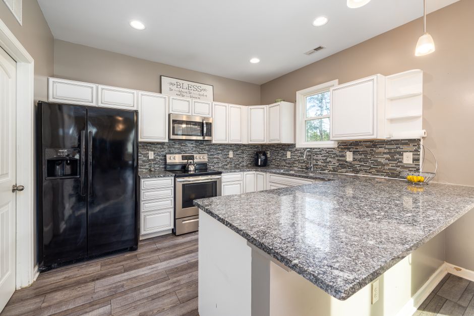 Elegant kitchen with sleek granite countertops and black appliances.