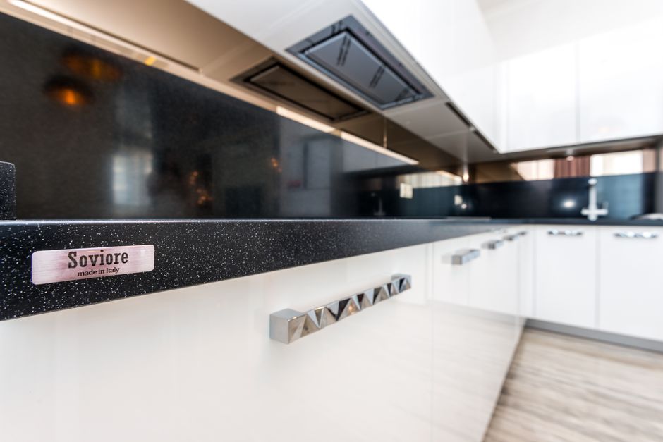 Sleek modern kitchen design featuring white cabinets.